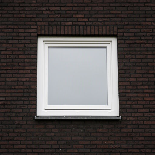 Close-up kunststof kozijn wit op donkere bakstenen arbeiderswoning gevel Tilburg